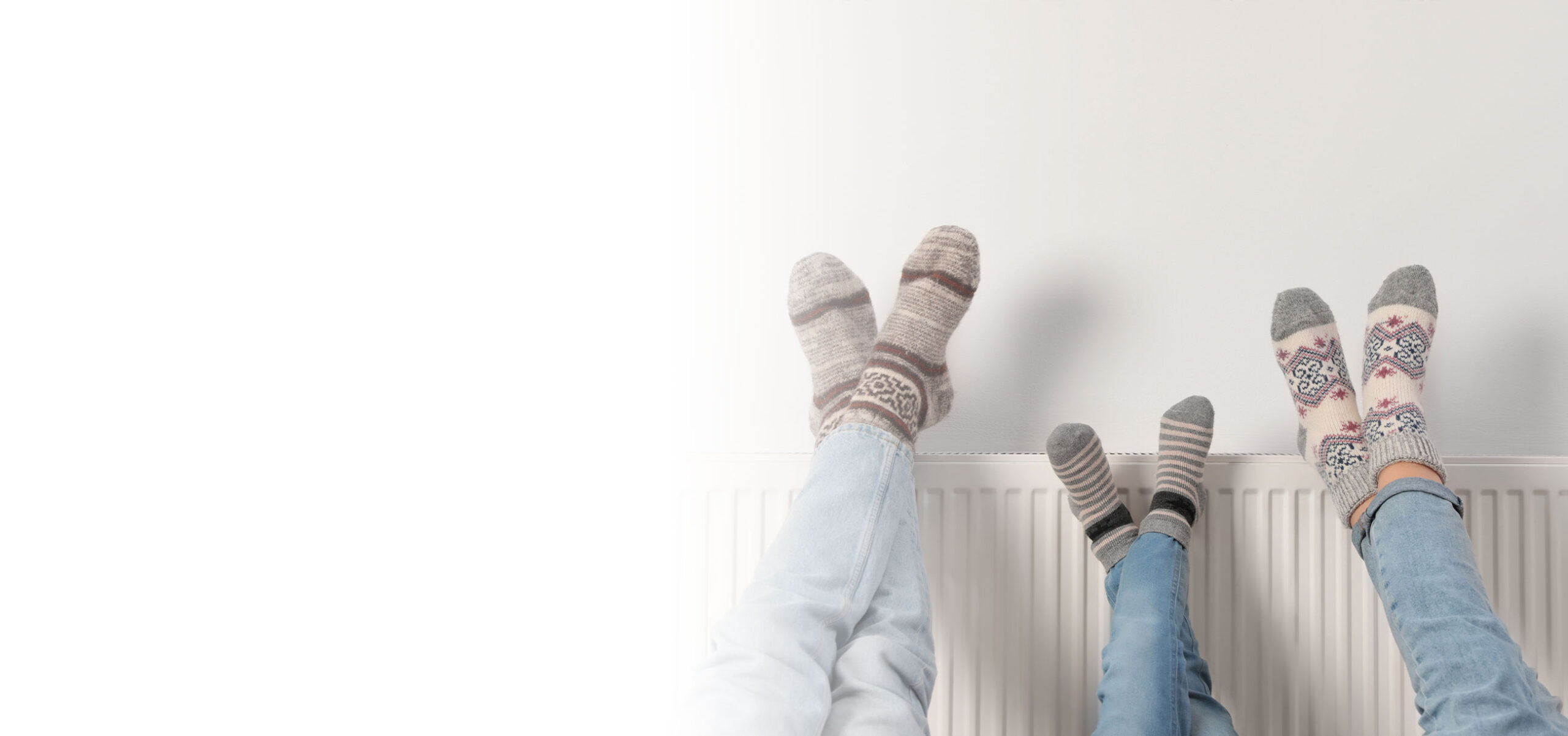 Familie wärmt die Beine an der Heizung, Nahaufnahme.